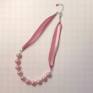 Pink pearl necklace with ribbon chain.